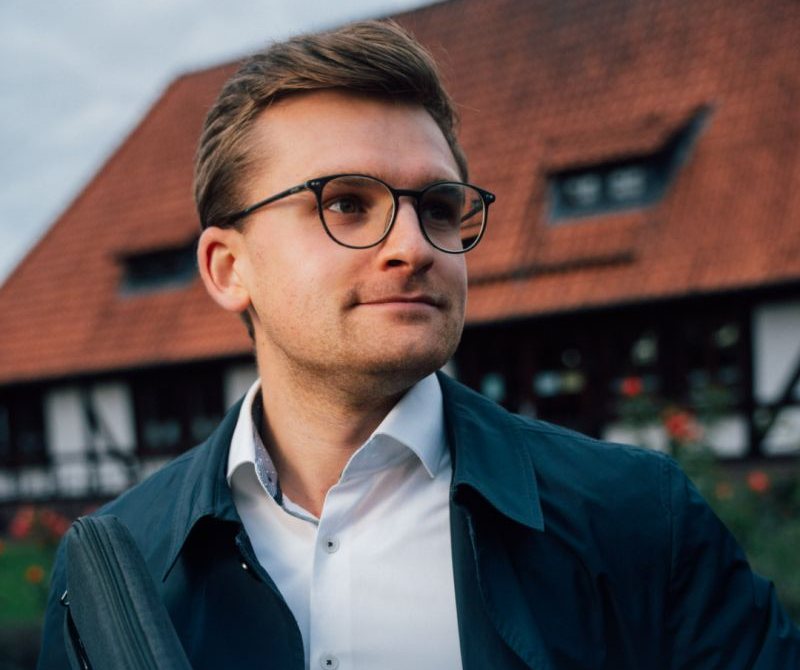 Lukas Honemann vor einem Fachwerkhaus