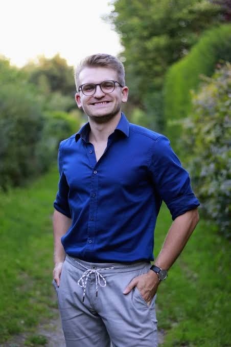 Lukas Honemann im blauen Hemd auf einem Weg im Grünen